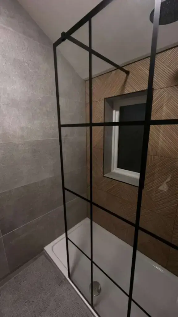 shower screen with black accents and woodlike flute tiles